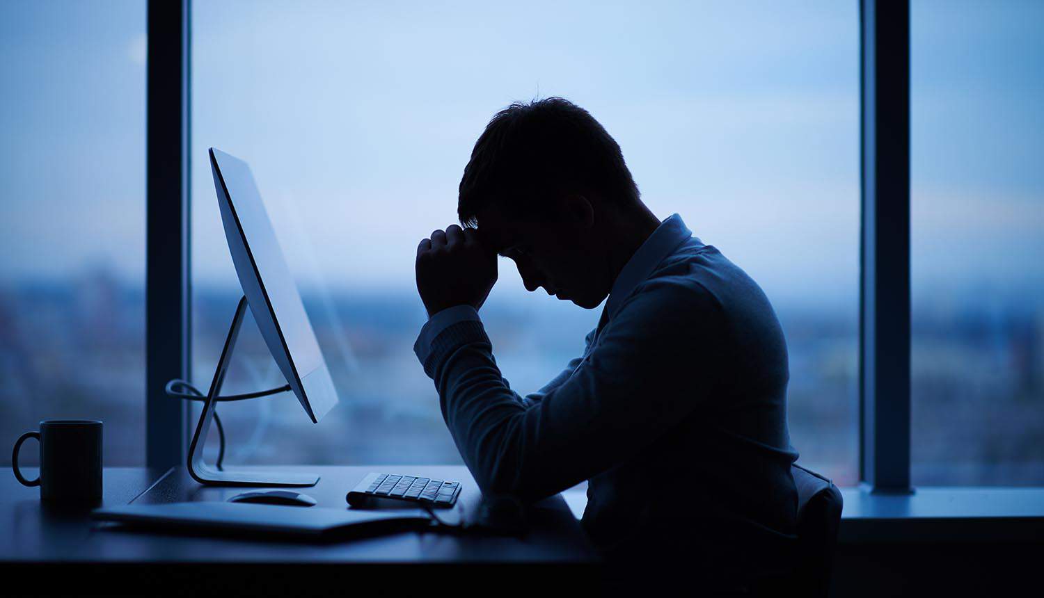 Stressed SOC analyst at workstation